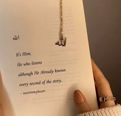 a person holding up a book with a chain attached to it