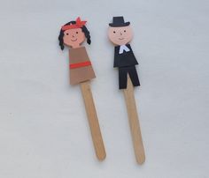 two wooden pegs with people on them sitting next to each other