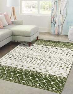 a green and white rug in a living room next to a couch with pillows on it