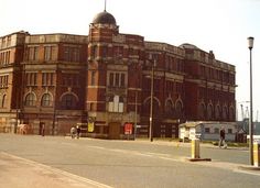 an old brick building sitting on the side of a road