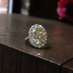 a diamond ring sitting on top of a wooden table