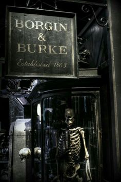 a skeleton is standing in front of a sign that says borrn & burke