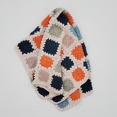 three crocheted dishcloths on top of each other in various colors and patterns