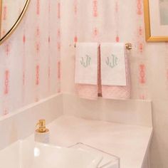 a bathroom with two towels hanging on the wall next to a sink and mirror in it