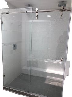 a bathroom with a glass shower door and white tile flooring on the walls is shown