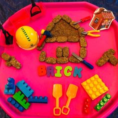 a child's play tray with toys and letters that spell out the word brick