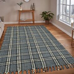 a living room with wooden floors and a blue plaid rug on top of the floor