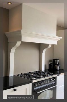 a stove top oven sitting inside of a kitchen next to a wall mounted range hood