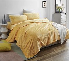 a bed with yellow sheets and pillows in a room