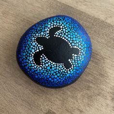 a painted rock sitting on top of a wooden table