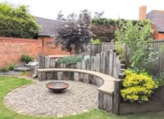 an outdoor garden with gravel and stone seating area, surrounded by brick fenced in areas