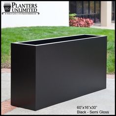 a large black planter sitting on top of a sidewalk