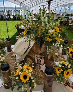 sunflowers and other flowers are on display under a tent