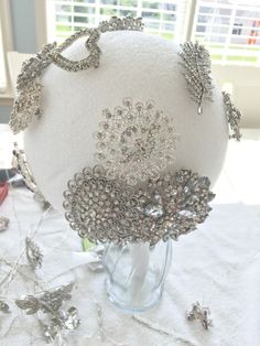 a white hat with lots of silver beads on it sitting on a table in front of a window