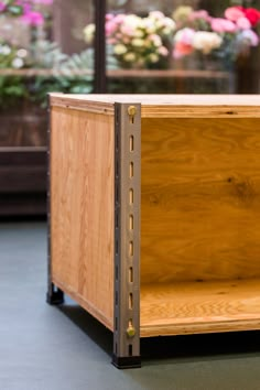 an open wooden box sitting on top of a table next to potted planters