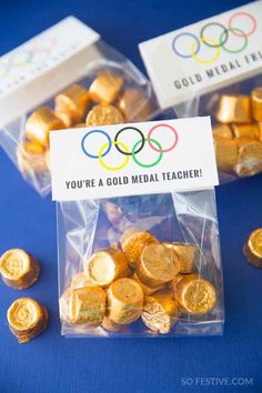 two bags filled with gold coins next to each other on top of a blue table