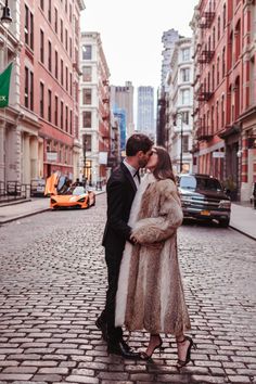 a man and woman are kissing on the street