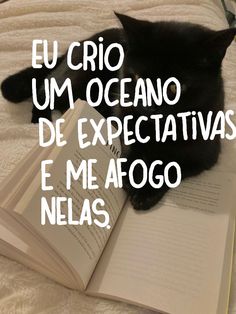 a black cat laying on top of an open book with the caption el crio um oceano de expectativvis e me ago nelas