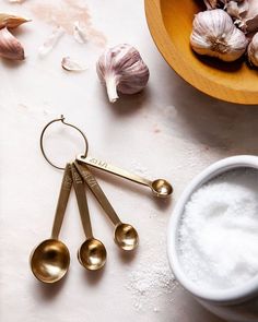 garlic, salt and spoons on a table