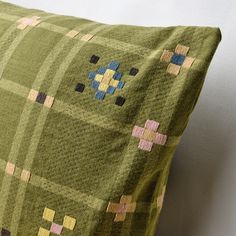 a green pillow with colorful squares on it