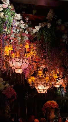 chandeliers and flowers are hanging from the ceiling