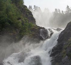 a waterfall with mist coming out of it