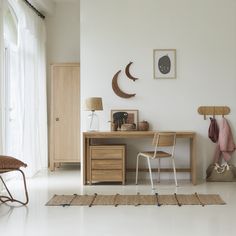 a room with a desk, chair and pictures on the wall above it is white tile flooring