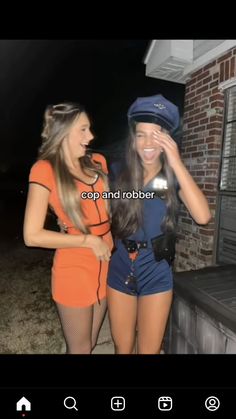 two young women dressed in costumes standing next to each other on the sidewalk at night