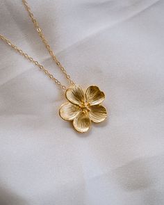 This Bloom Gold Necklace is perfect for letting your beauty blossom! Its golden brilliance sparkles like sunshine, and is sure to turn heads. Add a touch of glamour and make a statement with this gorgeous piece! NECKLACE FEATURES Material: Brass Size: 22.5 x 21.9mm 18K Matte Gold Plated Flower Charm 14K gold filled cable chain & necklace findings Model is wearing 18" length Golden Pendant Necklace, Flower Gold Necklace, Golden Necklace, Cable Chain Necklace, Freshwater Pearls Earrings, Bracelet Ring, Pretty Earrings, Opal Necklace, Flower Charm