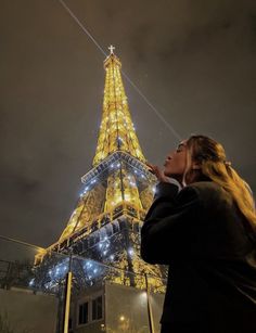 a woman standing in front of the eiffel tower