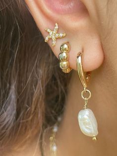 gold jewelry, gold necklace stack, gold earrings, summer jewelry, clean girl, it girl, coconut girl, aesthetic, gold jewelry aesthetic, chunky jewelry, summer, beaded jewelry, diy, small business, pearl jewelry, gold and pearl, pearl earrings, starfish studs, studs earring stack, piercings, lobe piercing Double Ear Piercing Ideas Unique, Gold Shell Earrings, Double Stacked Lobe Piercing, 3 Earring Stack, Double Piercing Earrings Ideas, Double Lobe Piercing Ideas, Gold Earring Aesthetic, Things To Bedazzle, Summer Beaded Jewelry