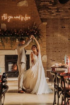 a bride and groom dancing in front of a fire place with the words, all you need is love