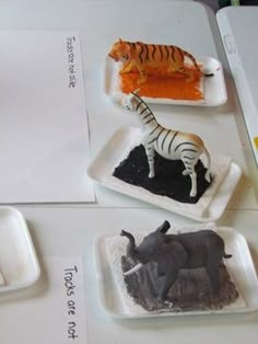 there are three trays with different types of animals on them, one zebra and the other an elephant