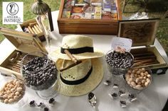 a table topped with lots of different types of hats on top of a white table cloth