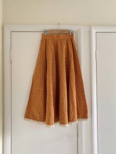 "Vintage 1970s Handmade Costume Cotton Mustard Floral Pattern Skirt. The skirt does up at the side with poppers. So beautiful and unique! Long flare style. Lace trim at the hem. Was made as a costume for a theatre  ~ handmade so might not be perfect.  Would fit around UK size 8 Skirt Measurements - Waist: 25\" Hips: 36\" Length: 32.5\" How to Care: Hand Wash When you unpack your order, hang it up and let it relax to let the creases drop out, either steam it or gentle press on the reverse side of Orange Cotton Skirt For Fall, Spring Cotton Skirt With Unfinished Hem, Retro Style Cotton Flowy Skirt Bottoms, Vintage Long Lined Skirt, Vintage Tiered Skirt For Fall, Retro Skirted Cotton Bottoms, Vintage Lined Maxi Skirt For Fall, Vintage Wide Leg Maxi Skirt For Spring, Vintage Flared Lined Skirt