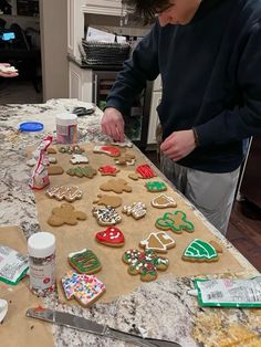 a man is decorating gingerbread cookies on a table