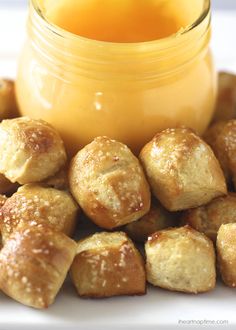 some bread rolls and a jar of orange juice on a white plate with the food in front of it