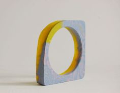 a ring made out of wood and painted with blue, yellow and white paint on it