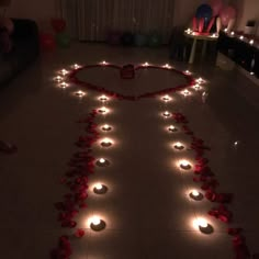 a heart made out of candles with roses on the floor and lights in the shape of a person's head