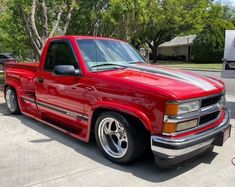 a red pick up truck parked in a driveway