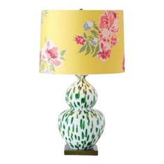 a lamp that is sitting on top of a wooden base with a flowered shade