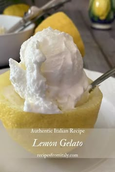 a lemon gelato is topped with whipped cream in a small cup on a white plate