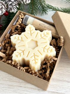 an open box with some soaps in it on a wooden table next to christmas decorations