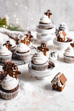 cupcakes decorated with gingerbread and frosting on a plate next to christmas decorations