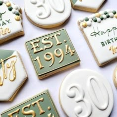 decorated cookies with white and green frosting are arranged on a table