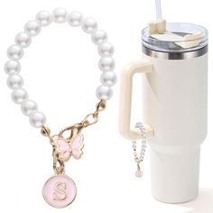 a coffee cup and bracelet with initial charm