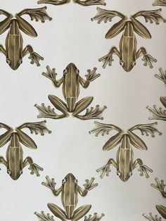 an image of a frog pattern on a wallpapered surface in gold and white