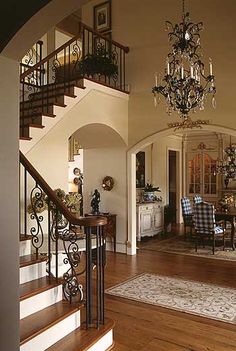 an elegant entry way with chandelier and dining room table in the center area