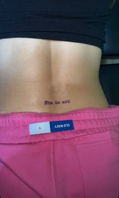 a woman's stomach with the words she is art written on her lower back