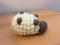 a crocheted sheep sitting on top of a wooden table